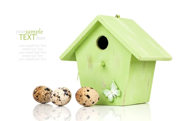 Quail eggs with birdhouse, on a white background — Stock Photo, Image