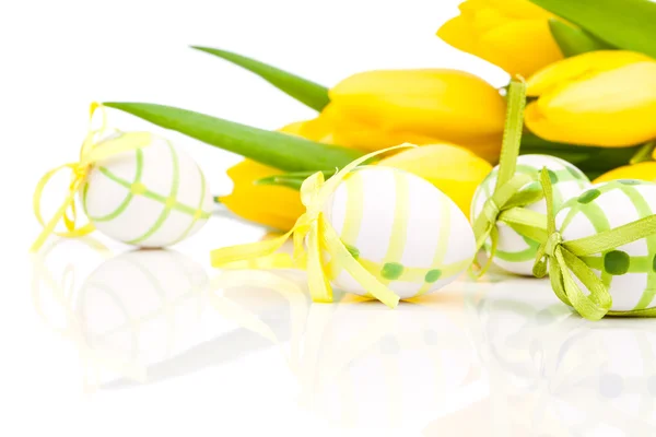 Huevos de Pascua con flores de tulipán amarillas aisladas sobre fondo blanco —  Fotos de Stock