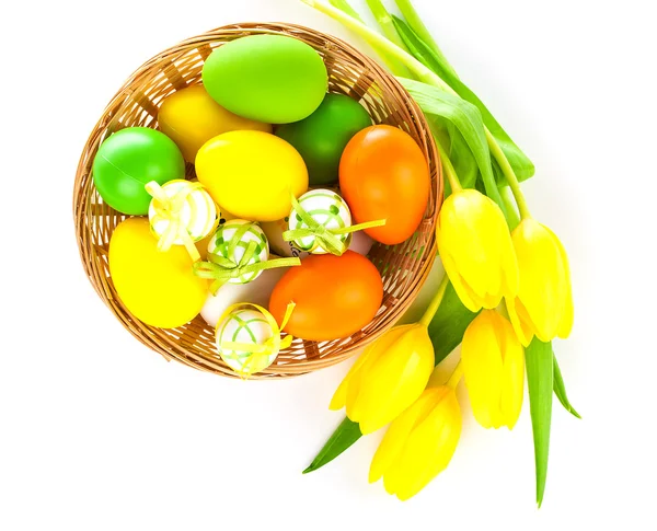 Cesta com ovos de páscoa e tulipas amarelas, sobre fundo branco — Fotografia de Stock
