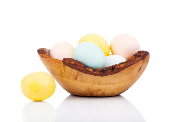 Huevos de Pascua en cuenco de madera, aislados sobre fondo blanco — Foto de Stock