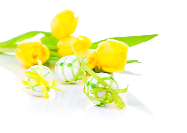 Ovos de Páscoa com flores de tulipa amarelas isoladas em backgrou branco — Fotografia de Stock