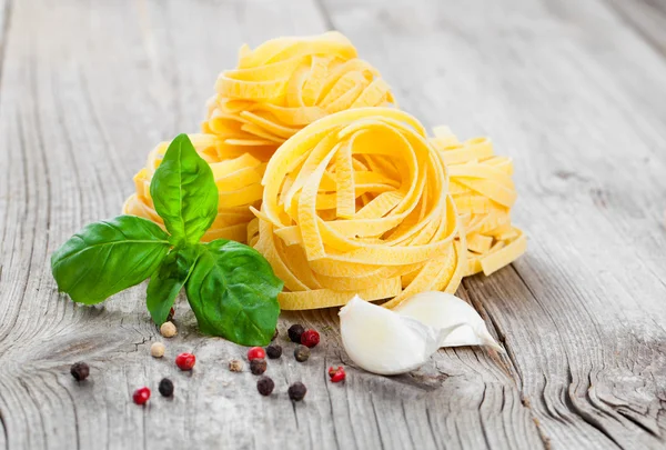 Nido de fettuccine de pasta italiana, sobre fondo de madera — Foto de Stock