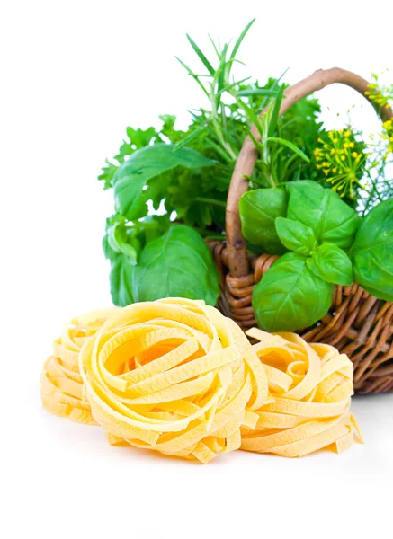 Italian pasta fettuccine nest with wicker basket green herbs, on — Stock Photo, Image