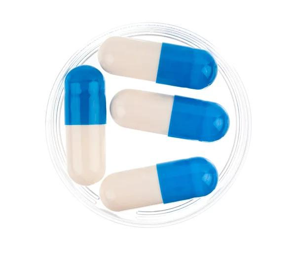 Gros plan des capsules médicales bleues sur fond blanc — Photo