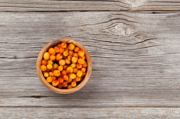 Gefrorene Sanddornbeeren auf dem hölzernen Hintergrund — Stockfoto