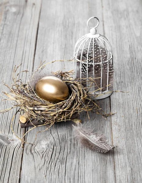 Golden egg in nest, on wooden background — Stock Photo, Image