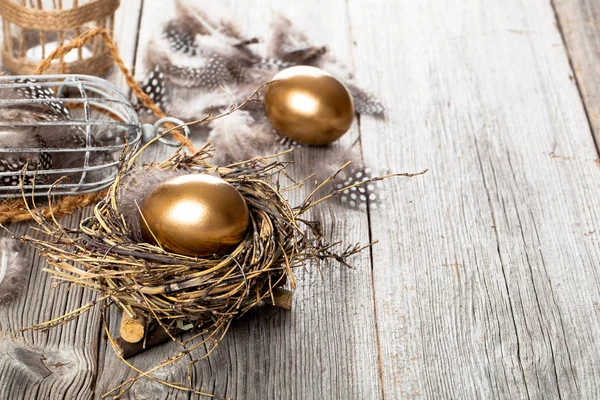 Golden egg in nest, on wooden background — Stock Photo, Image