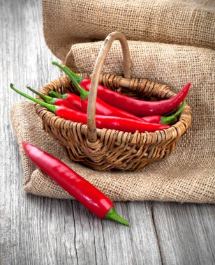 çuval bezi üzerinde ahşap ba ile hasır sepet içinde kırmızı biber biber
