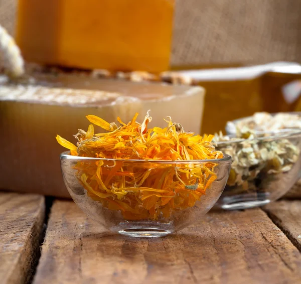 Herbal calendula in the glass bowl, on wooden background — Stock Photo, Image