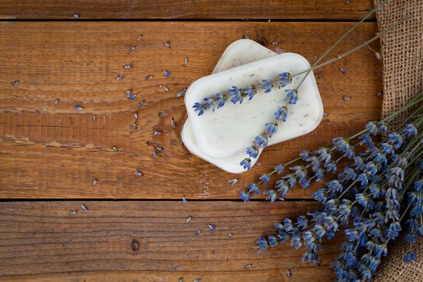 Seifenstücke mit Lavendel auf rustikalem Holzgrund — Stockfoto