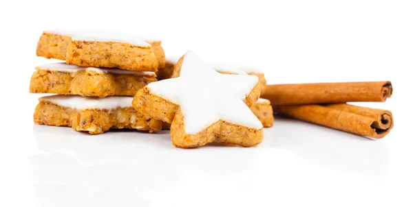 Star shaped cinnamon biscuit and cinnamon sticks on white backgr — Stock Photo, Image