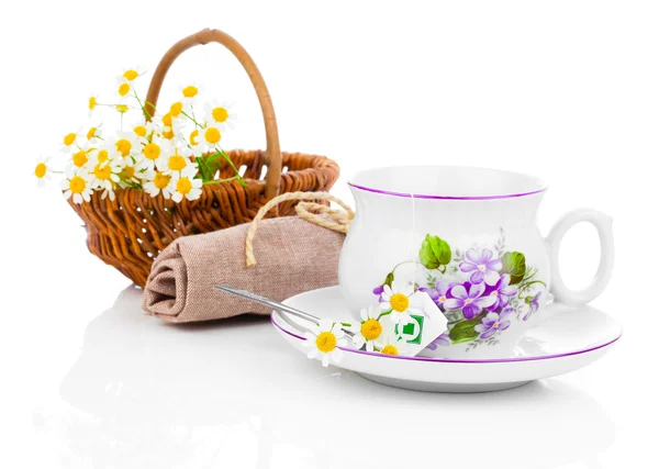 Taza con flores frescas de manzanilla y bolsitas de té, aisladas en blanco — Foto de Stock