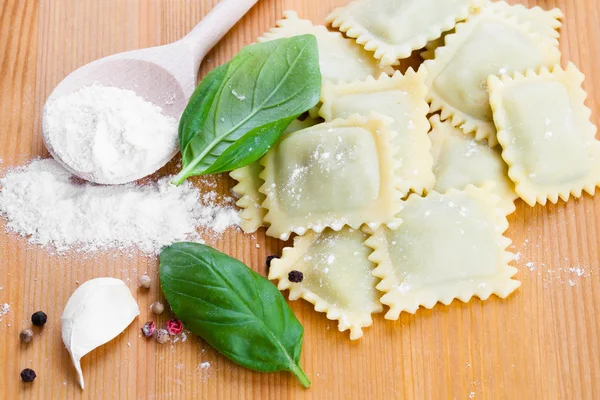 Hemlagad pasta ravioli med färsk basilika, isolerade över trä ba — Stockfoto