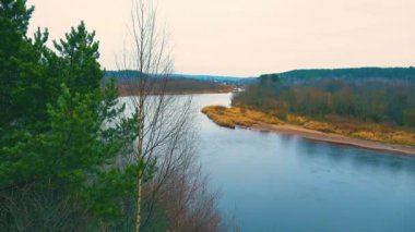Kış gökyüzü, kış nehrinin soğuk suyuna hafif bir kartopu serper..