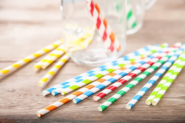 Colorful paper straws on wooden background. Event and party supplies. Selective focus. Copy space
