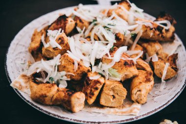 Beyaz bir tabakta soğanlı shashlik pişirdim. Kızarmış domuz eti ve kıtır kıtır. Partide et. Izgara domuz eti. Yakın plan.. 