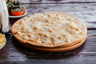 Restoranda tahta tahtada dört peynirli pizza.. 