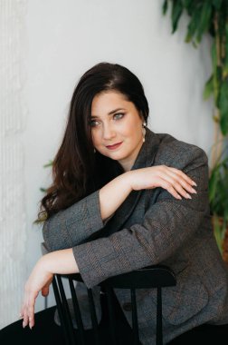 Gülümseyen güzel yeşil gözlü esmer. Kadın bir ofis tarzı giyinmiş. Mutlu Bir Kadının Portresi.