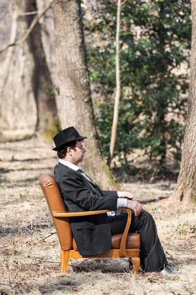 Человек, сидящий один в кресле — стоковое фото
