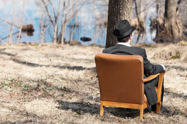 Homem sentado sozinho em uma poltrona — Fotografia de Stock