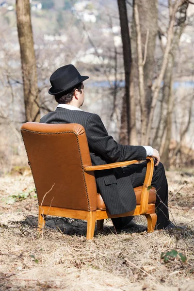 単独で、肘掛け椅子に坐っていた男 — ストック写真