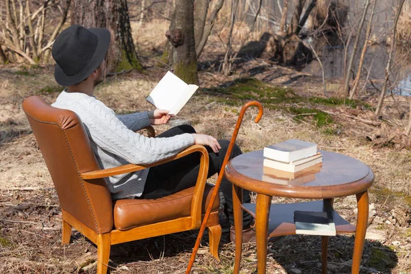 Man läser en roman i skogen — Stockfoto