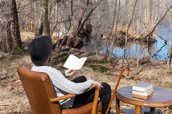 Man reading a novel in the woods — Stock Photo, Image