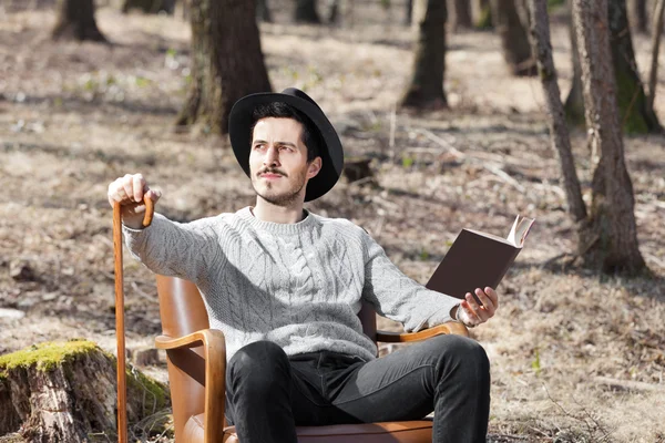 Homme lisant un roman dans les bois — Photo