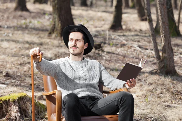 Uomo che legge un romanzo nel bosco — Foto Stock