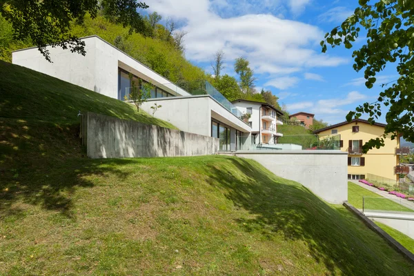 Бетонный дом с зеленой лужайкой — стоковое фото