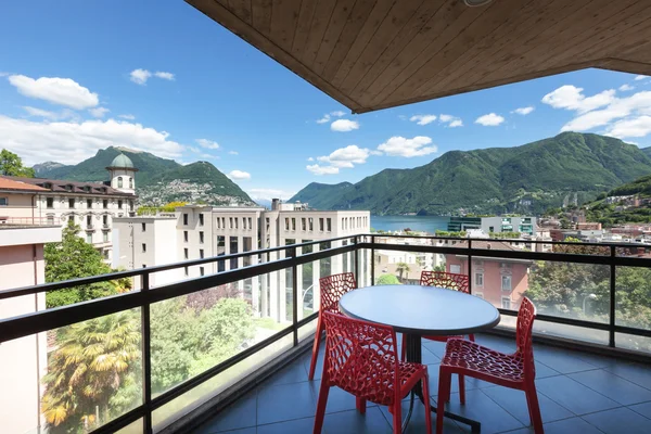 Balcón con vistas a la ciudad y al lago con mesa — Foto de Stock