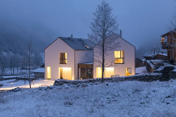 Moderna Casa Blanca Con Ventanas Luminosas Rodeadas Montaña Nieve Árboles —  Fotos de Stock