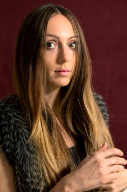 Kürklü kadın stüdyoda Bordeaux 'nun önünde oturuyor.. 