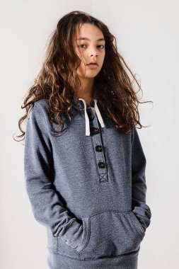 Tembel suratlı genç poz verirken mavi bir kazak giyiyor.