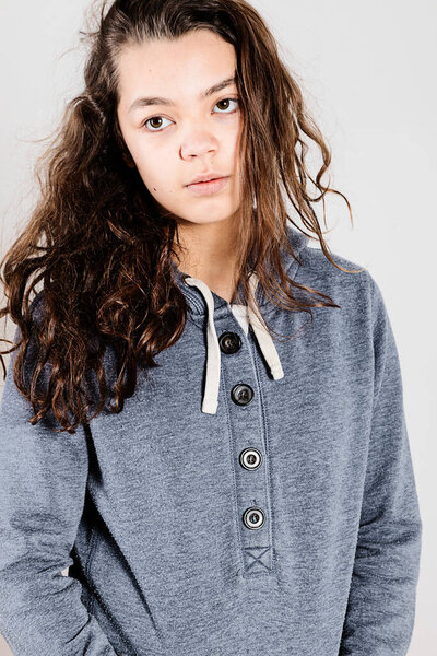 Teen with lazy face wearing a blue sweatshirt while posing