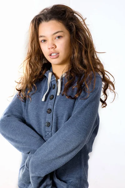Teen with lazy face wearing a blue sweatshirt while posing