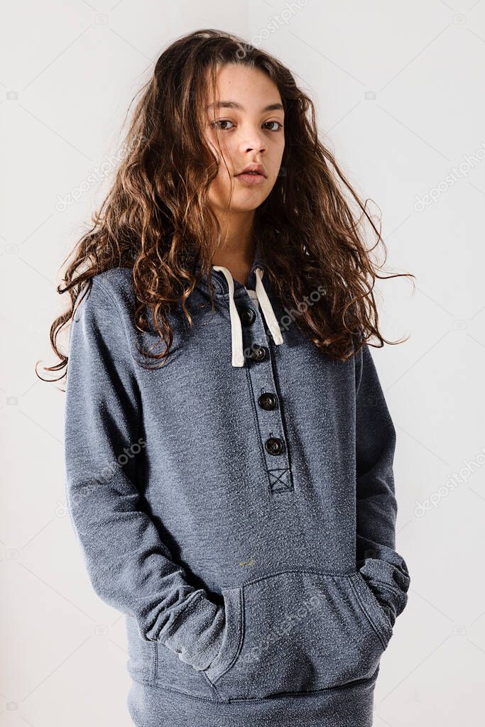 Teen with lazy face wearing a blue sweatshirt while posing