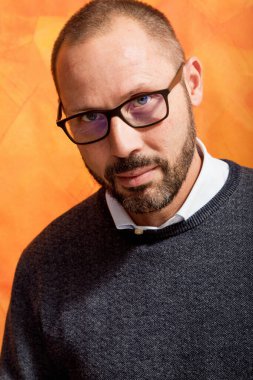 Süveter, gömlek ve gözlüklü şık giyimli iş adamının portresi.