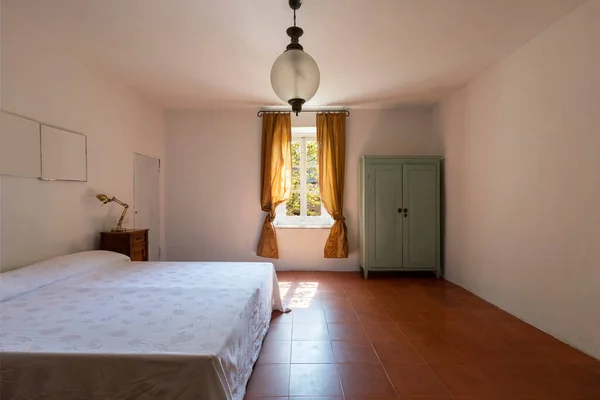 Interior of a double bedroom in a rustic and country style. We are in Italy. Nobody inside