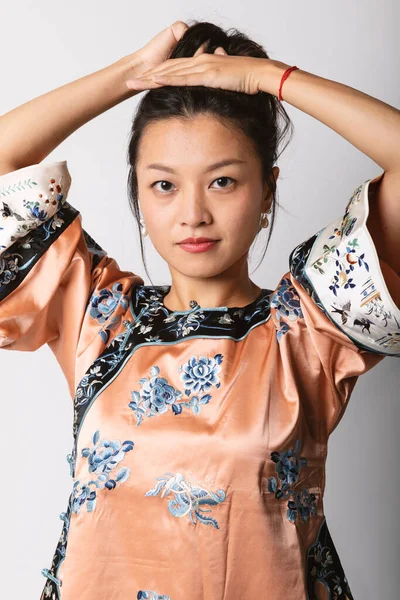 Geleneksel Çin Gömlekli Genç Asyalı Kız Saçını Topluyor Beyaz Arkaplanda — Stok fotoğraf