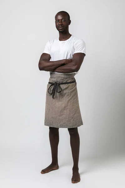 Afrikansk Pojke Med Förkläde Utgör Tre Fjärdedelar Vit Bakgrund Fotostudio — Stockfoto