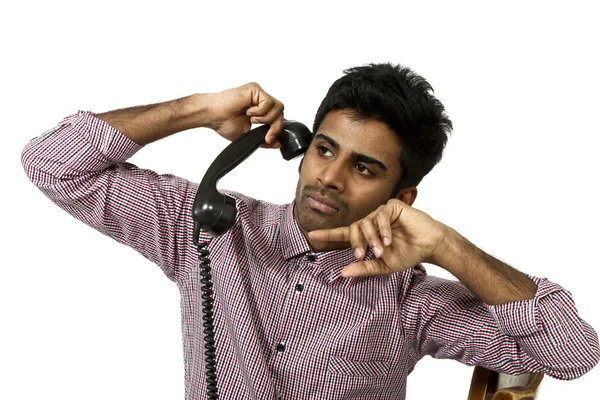 Junger Mann kämpft mit einem verrückten Telefon — Stockfoto