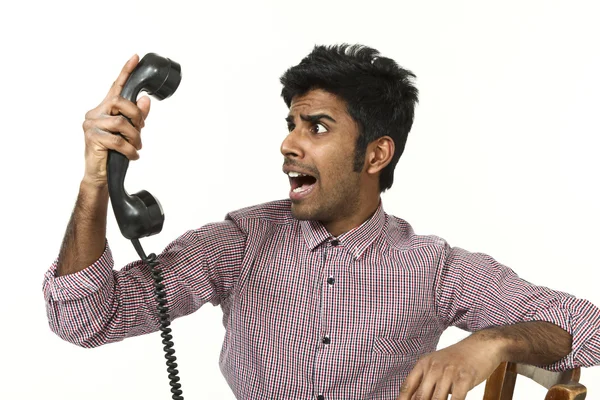 Junger Mann kämpft mit einem verrückten Telefon — Stockfoto