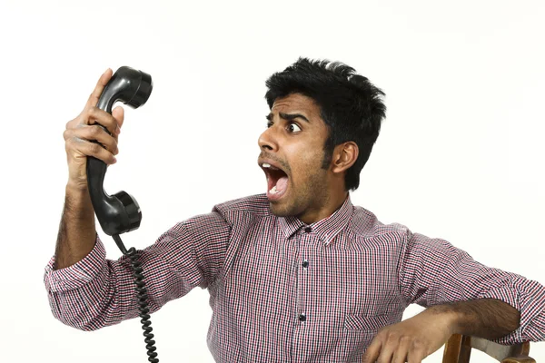 En ung mann som sliter med en sprø telefon – stockfoto