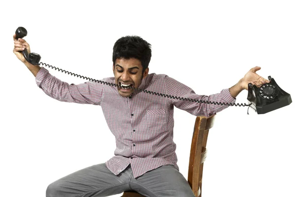 Jonge man die worstelt met een gek telefoon — Stockfoto
