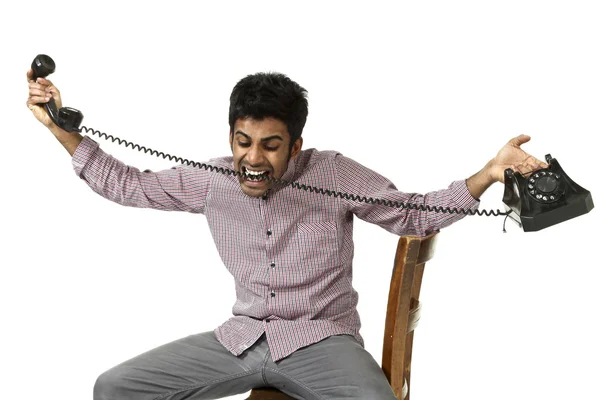 Young man struggling with a crazy telephone — Stock Photo, Image