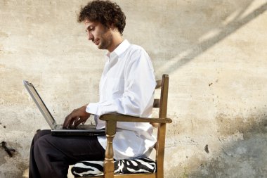 Defter üzerinde çalışma sandalyede oturan genç adam