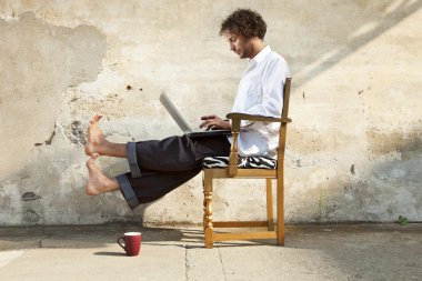 Defter üzerinde çalışma sandalyede oturan genç adam