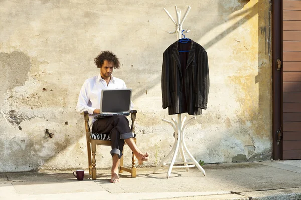 노트북에서 작업 하는 자에 앉아 젊은 남자 — 스톡 사진