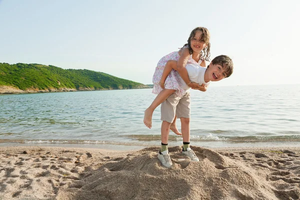 Menino e menina brincando na praia — Fotografia de Stock